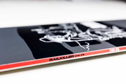 Nitro T1 Snowboard 2027 black top sheet with white graffiti graphic and red sidewall