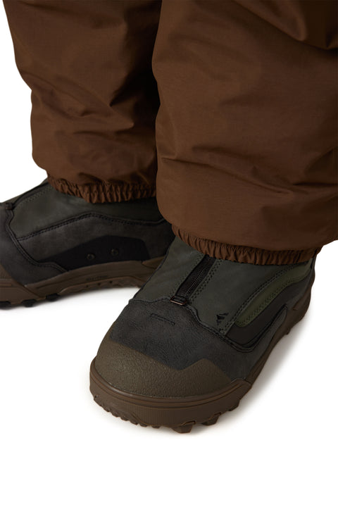 686 Men's Dojo Gore-Tex Shell Pant in brown with dark olive snow boots