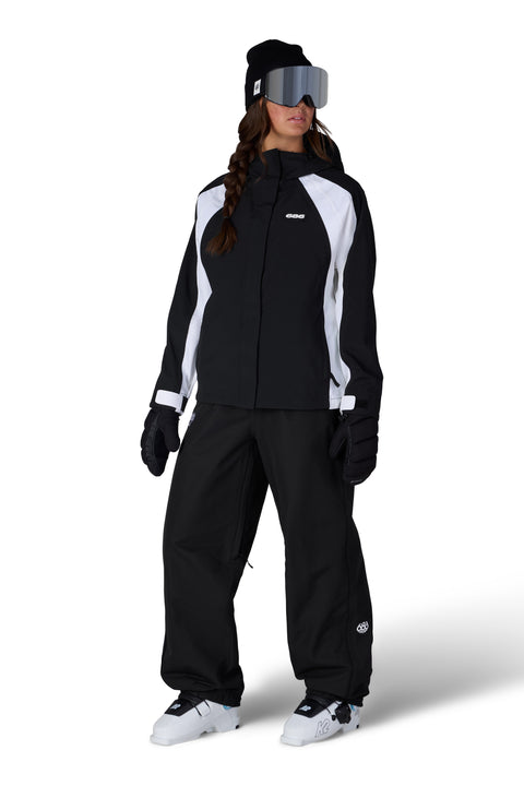 686 Women's black and white shell ski jacket with goggles, beanie, and ski pants
