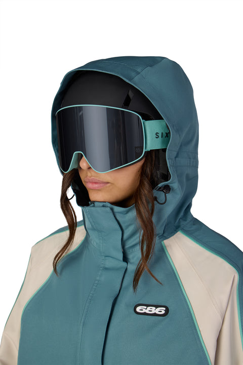 Women's teal and cream 686 shell jacket with helmet-compatible hood
