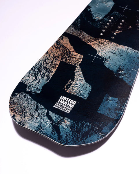 Lib Tech T.Rice Pro snowboard base with dark abstract art in blue, black, and copper tones