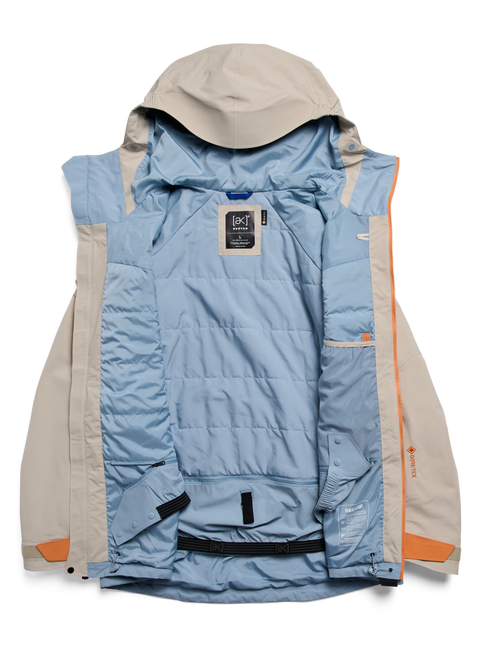 Burton AK Swash GORE-TEX jacket open, showing tan exterior and blue quilted interior lining.