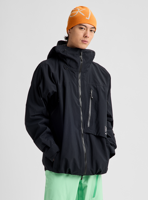 Men's black hooded GORE-TEX ski jacket with zipper chest pocket, worn with orange beanie