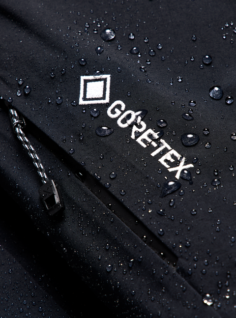 Black GORE-TEX jacket close-up with water beading on fabric surface