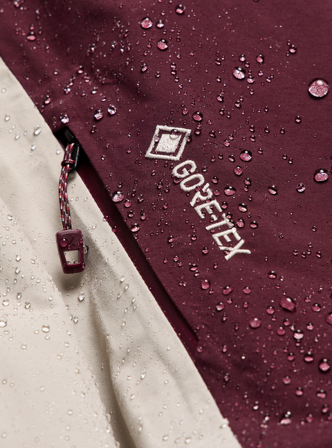 Burton ak GORE-TEX jacket detail showing water beading on burgundy and tan fabric
