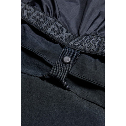 Close-up detail of waistband snap closure and webbing strap on men's snow pants