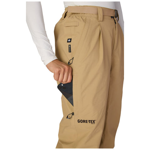 Close-up detail of women's Gore-Tex ski pant side pocket with phone being inserted
