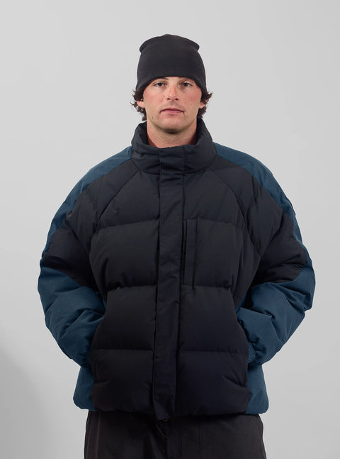 Analog Men's Toughy Puffy Down Jacket in black with teal blue sleeves and beanie