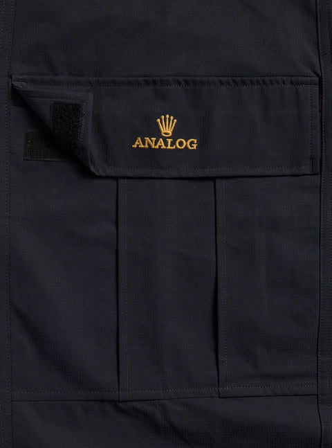 Black cargo pant pocket with gold embroidered Analog crown logo and velcro closure