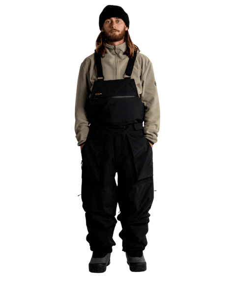 Autumn Butte 3L black bib snow pants with chest pocket, worn with beanie