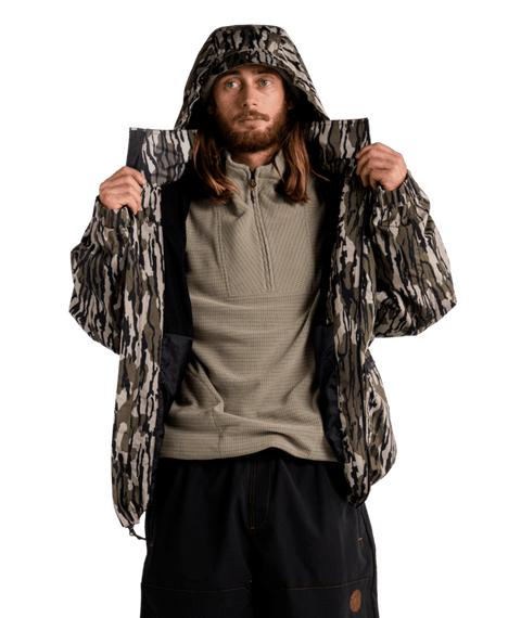 Men's camo hooded puffer jacket open over olive quarter-zip fleece pullover