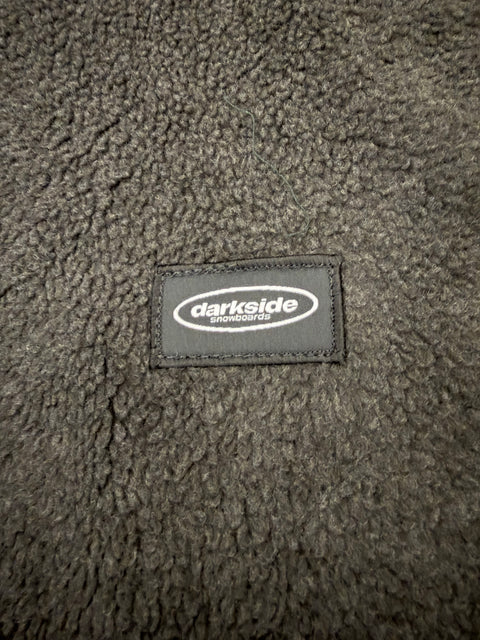 Dark grey fleece fabric close-up with Darkside Snowboards woven patch label
