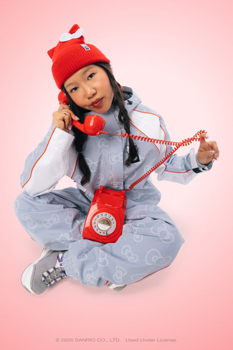 Red Hello Kitty beanie with white bow detail worn by model in pink setting