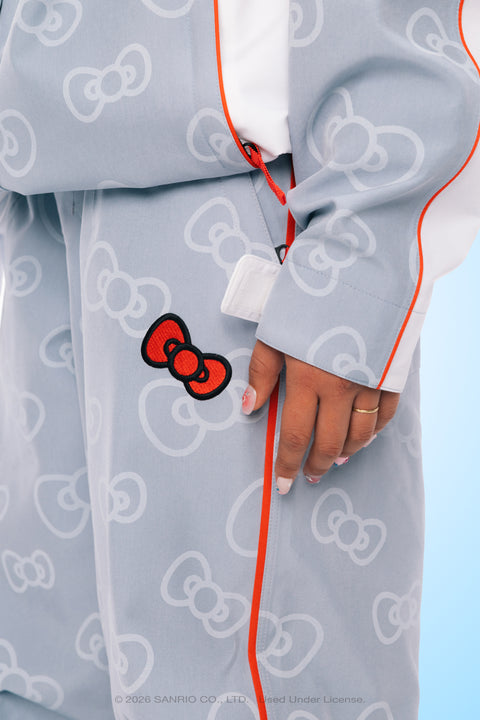 Gray Hello Kitty print ski pants with red bow patch and orange piping detail.