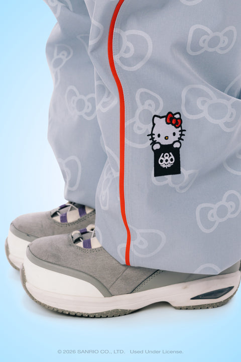 Gray Hello Kitty patterned shell pants with red stripe and embroidered patch detail