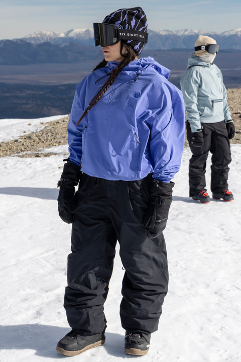 686 Women's periwinkle blue crop hoodie worn on snowy mountain slope