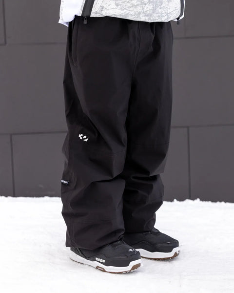 ThirtyTwo Men's Classic black snow pants with relaxed fit and snowboard boots