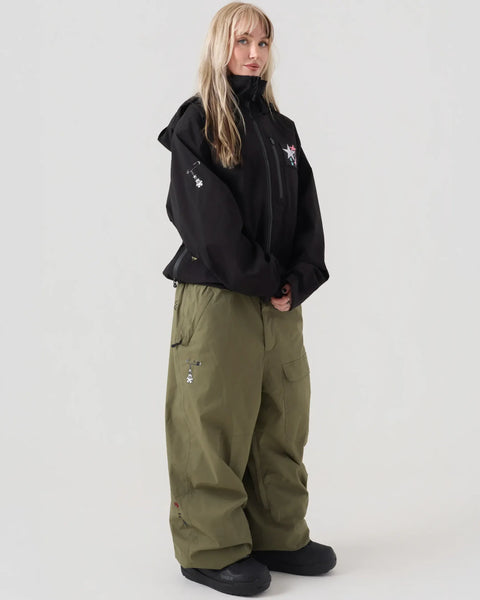 ThirtyTwo Jib snowboard pants in olive green, wide leg fit, worn with black jacket