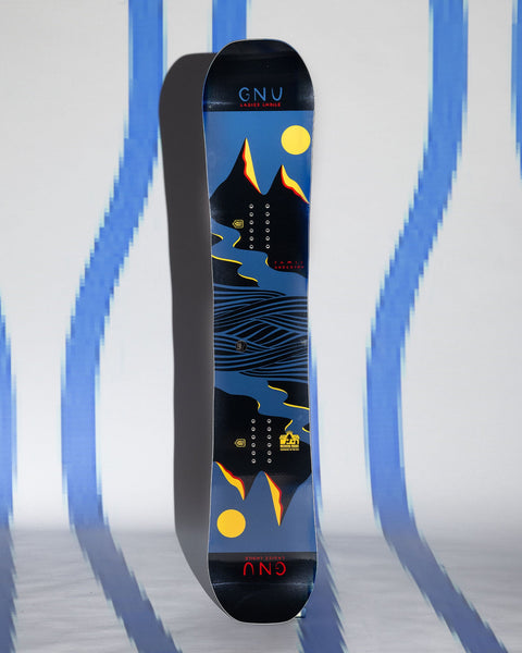 GNU Ladies Choice snowboard standing upright showing mountain landscape graphic on deck