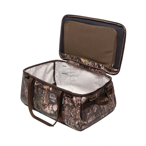Open Herschel duffle bag in Realtree camo pattern showing spacious interior and brown handles