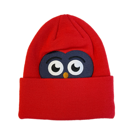 Red knit youth beanie with embroidered cartoon owl eyes peeking over the cuff