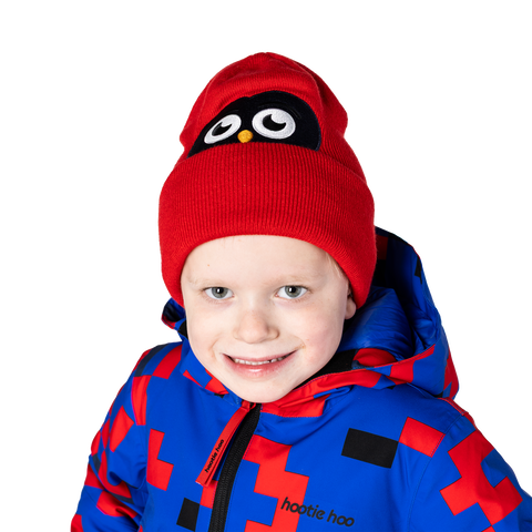 Child wearing a red knit beanie with embroidered owl face design and coordinating jacket