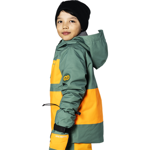 Child model wearing insulated hooded winter jacket with owl logo patch, side profile view