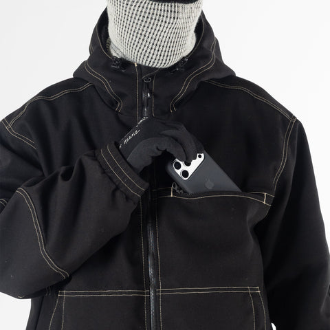 Detail shot of black workwear jacket chest pocket with gloved hand inserting smartphone