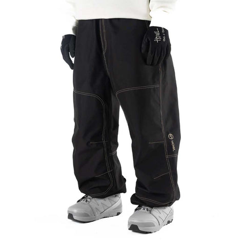 Howl men's baggy workwear snow pants with contrast stitching and gloves tucked in pockets