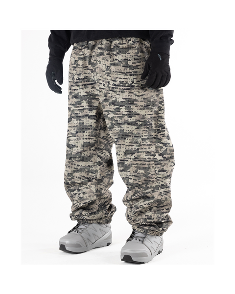 Men's baggy snow pants in digital camouflage pattern worn with snowboard boots and gloves