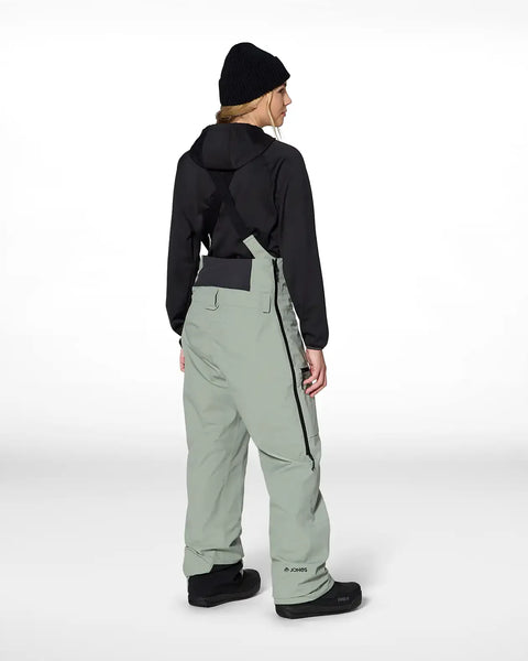 Back view of women's insulated snow bib pants with suspenders and cargo pocket detail