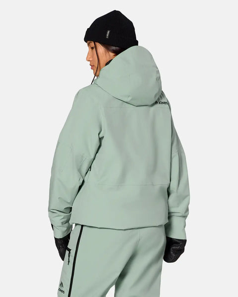 Woman wearing Jones Snowboards insulated snow jacket from behind, with hood and matching pants