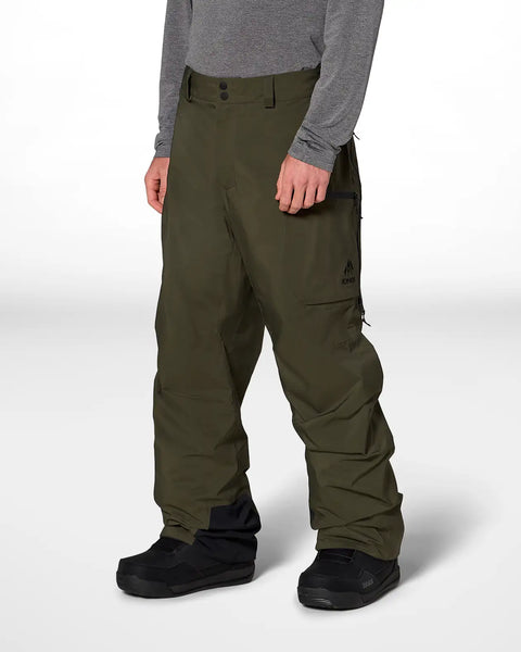 Men's olive green snow pants with cargo pockets and snowboard boots, side view