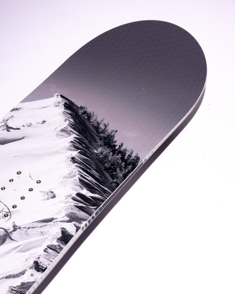 Lib Tech snowboard top sheet featuring a black and white mountain landscape graphic, close-up tip view