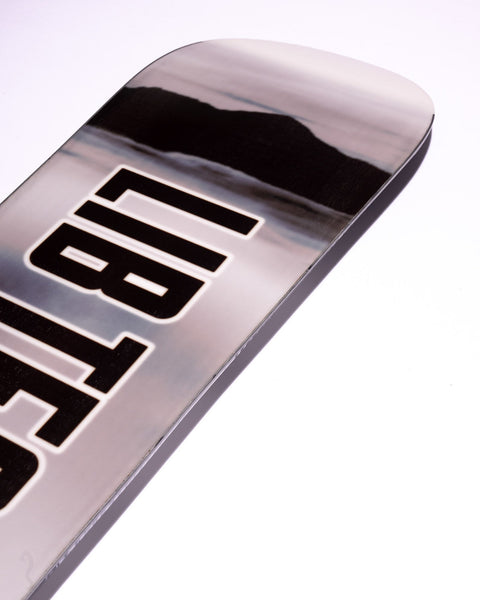 Close-up detail of Lib Tech snowboard tip showing metallic chrome topsheet with bold black lettering
