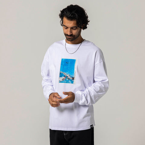 Male model wearing white long-sleeve t-shirt with mountain snowboard photo graphic on chest
