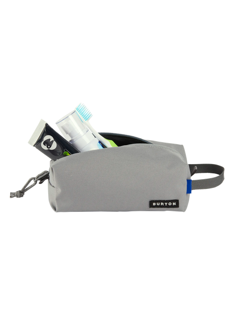 Burton gray toiletry bag open with toothbrush, spray bottle, and travel items inside