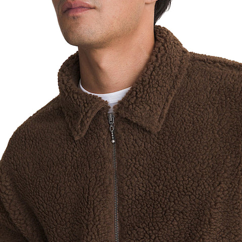 Close-up detail of a men's brown sherpa fleece zip-up jacket with spread collar